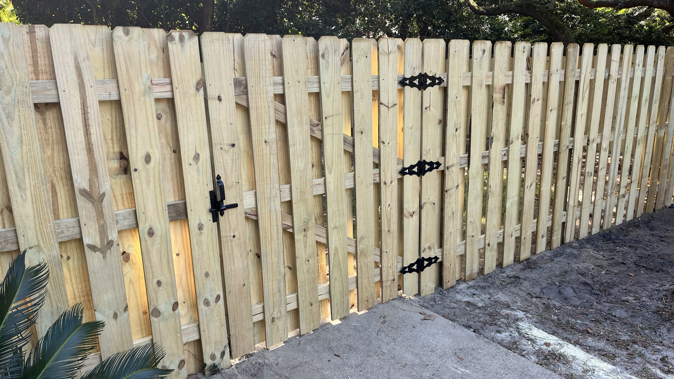 Wood privacy fence with a double gate and black hardware